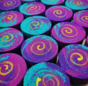 
            
                Load image into Gallery viewer, Round disk shaped Bath bombs, with colours of pink, purple, teal with a gold spiral on top
            
        